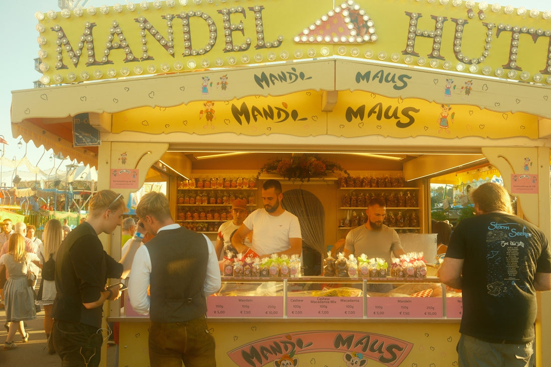 People at a busy fair food stand selling almonds.